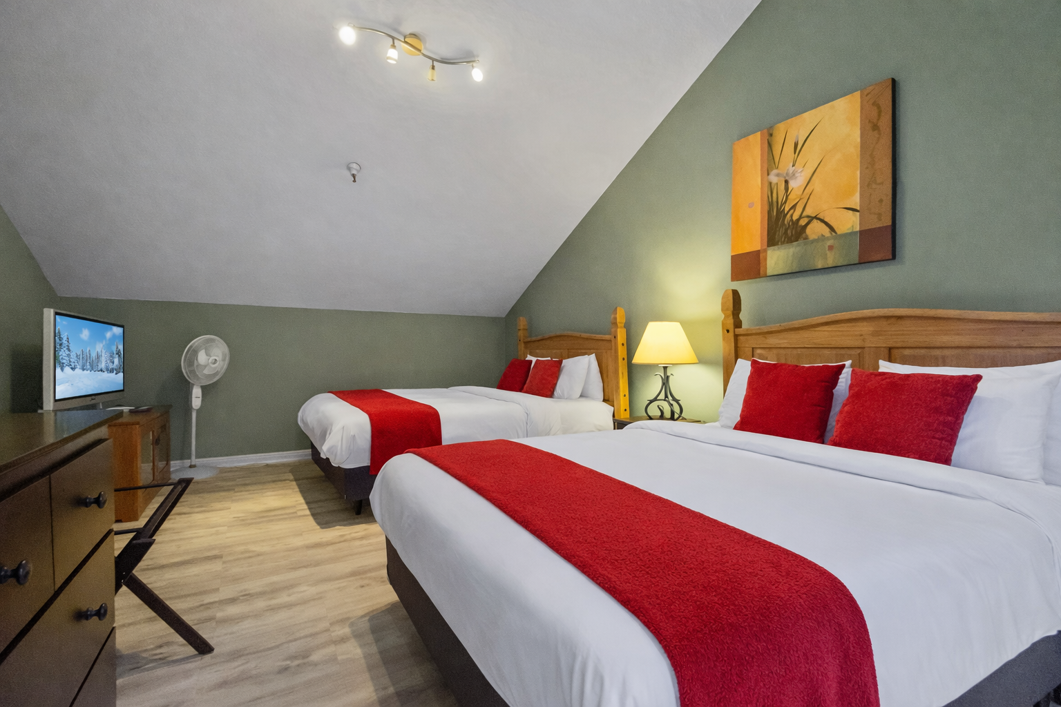 Comfortable & modern double room with stylish red accents, wood flooring, and large windows. A relaxing space for your Park City stay.