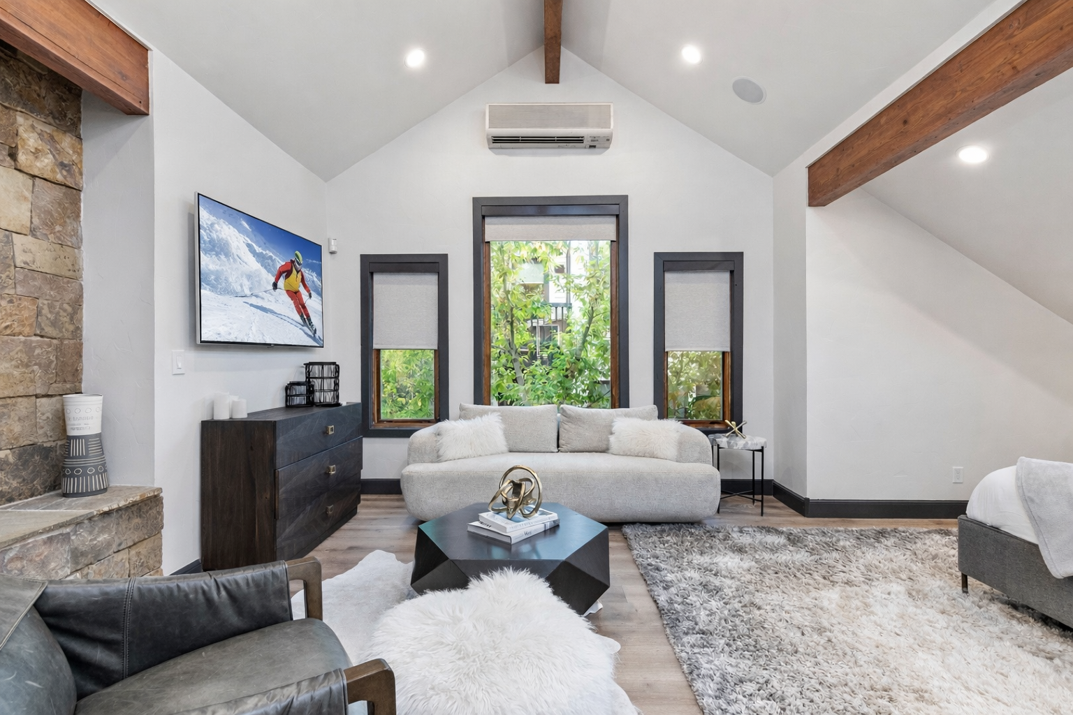 Retreat to the luxurious master suite featuring a king-size bed, stunning vaulted ceilings, exposed wooden beams, and a charming barn door. Your perfect mountain sanctuary awaits.