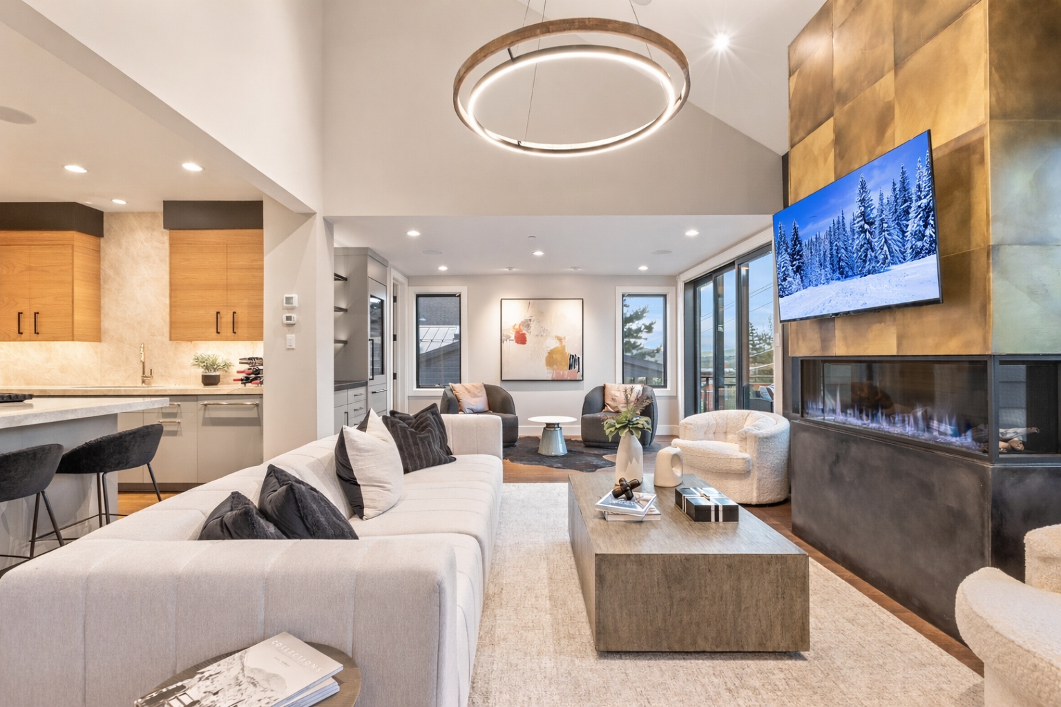 Unwind in the open-concept living area featuring a striking gold fireplace, vaulted ceilings, and comfortable seating