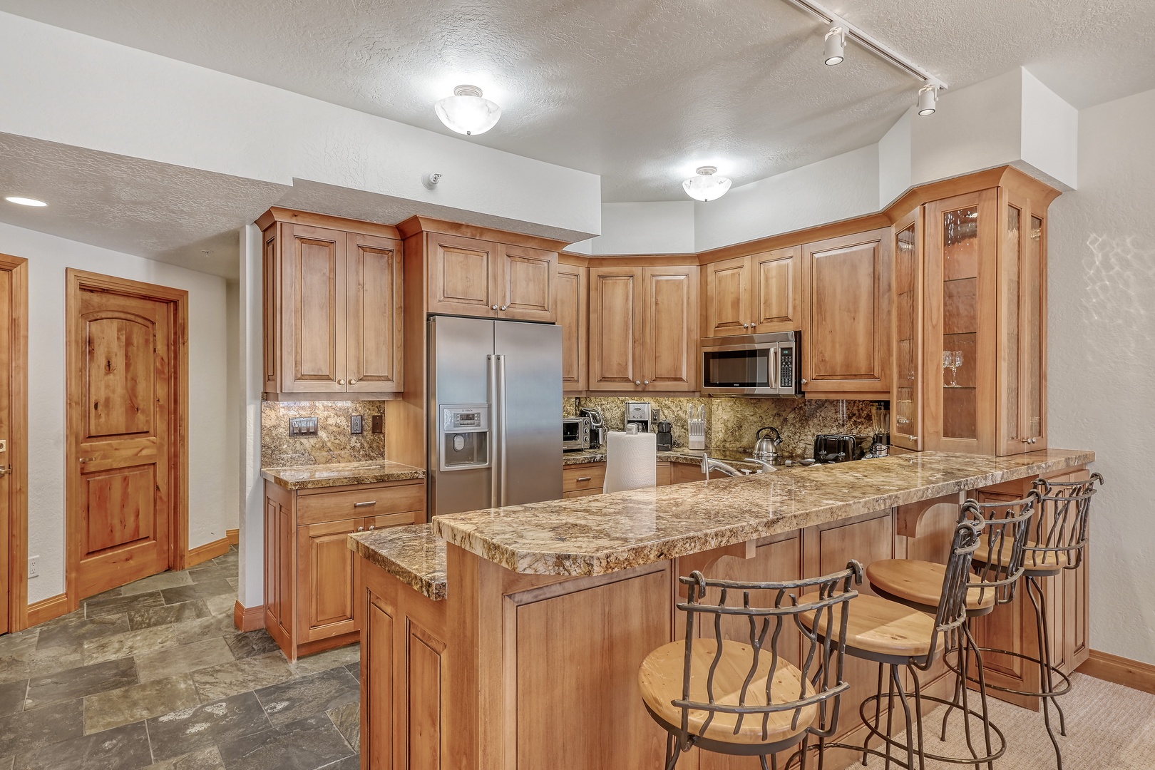 Your spacious kitchen features warm wood cabinetry, granite countertops, and stainless steel appliances—perfect for preparing memorable meals during your stay.