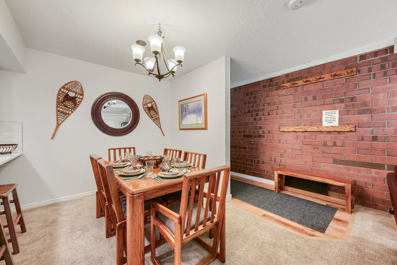 Gather around the rustic dining table with seating for six, where warm wood tones and charming snowshoe décor create a cozy mountain atmosphere for your memorable meals together.