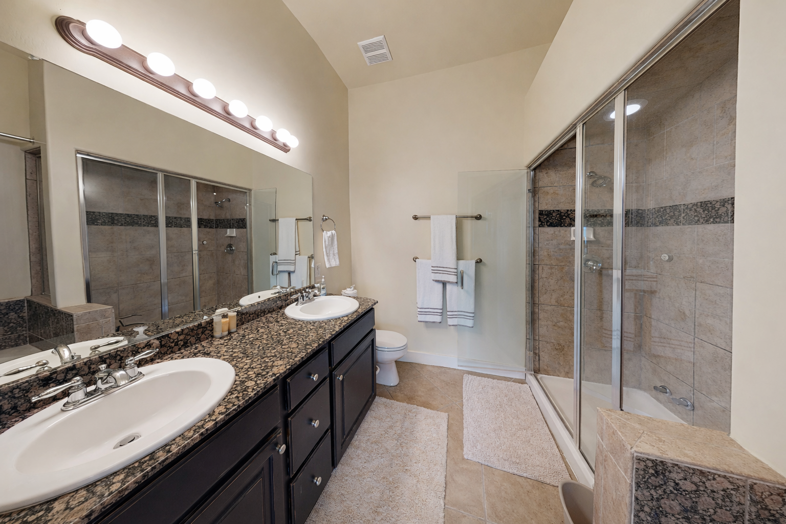 Indulge in your private spa-like retreat with dual vanities, granite counters, and a luxurious glass shower perfect for unwinding after adventures.