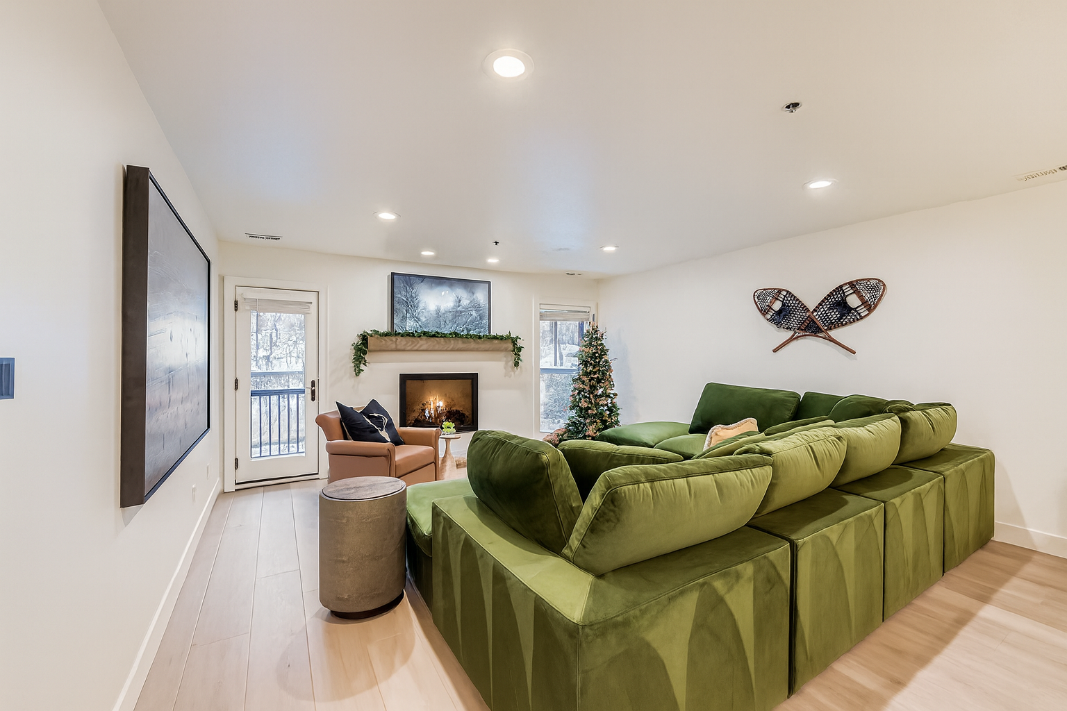 Sink into the plush green sectional and enjoy cozy evenings by your private fireplace in this stylish living space with mountain-themed decor.