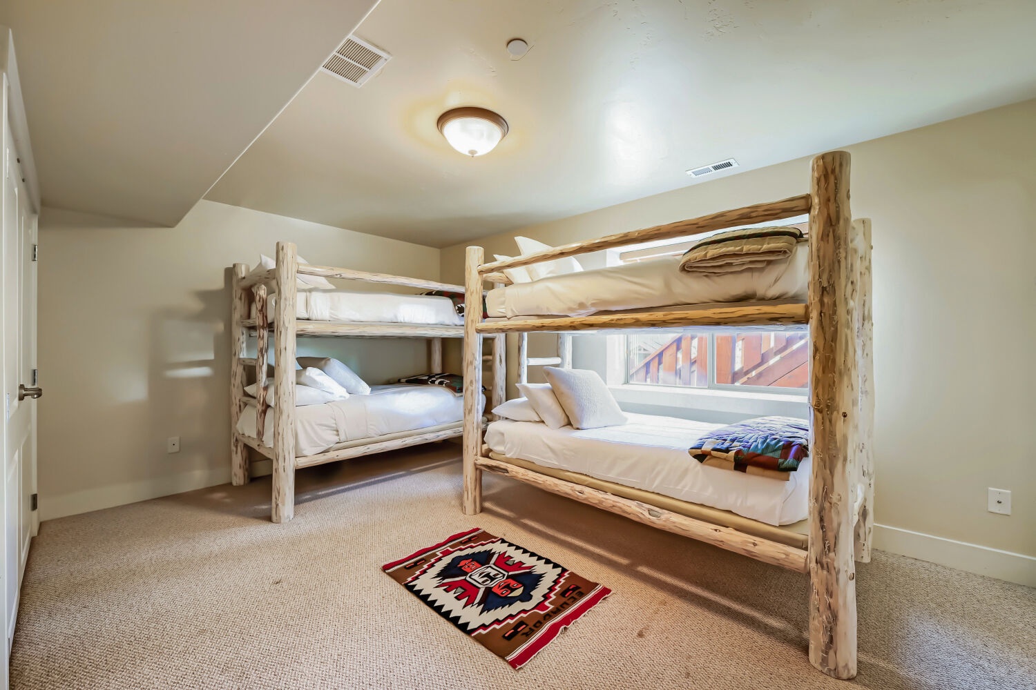Rustic log bunk beds await your crew in this cozy room with mountain views. Perfect for group getaways or family adventures.