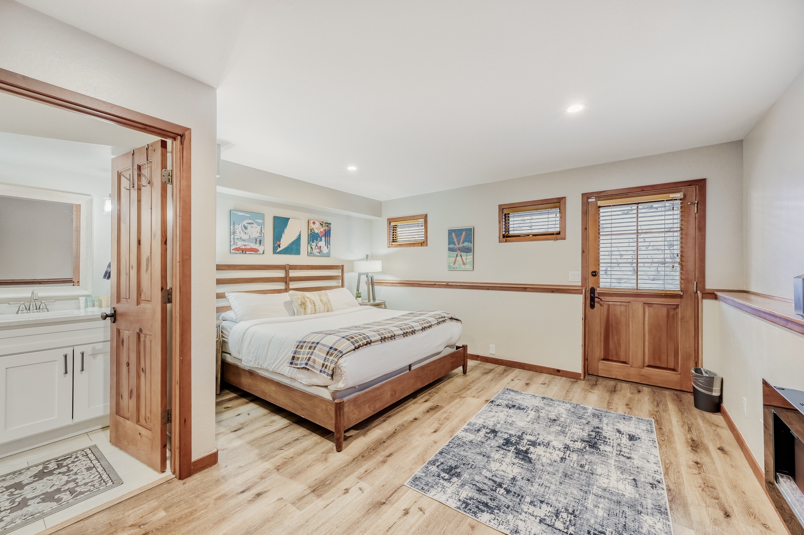 Unwind in your spacious bedroom featuring warm wood details, cozy plaid bedding, and peaceful artwork that creates the perfect retreat.