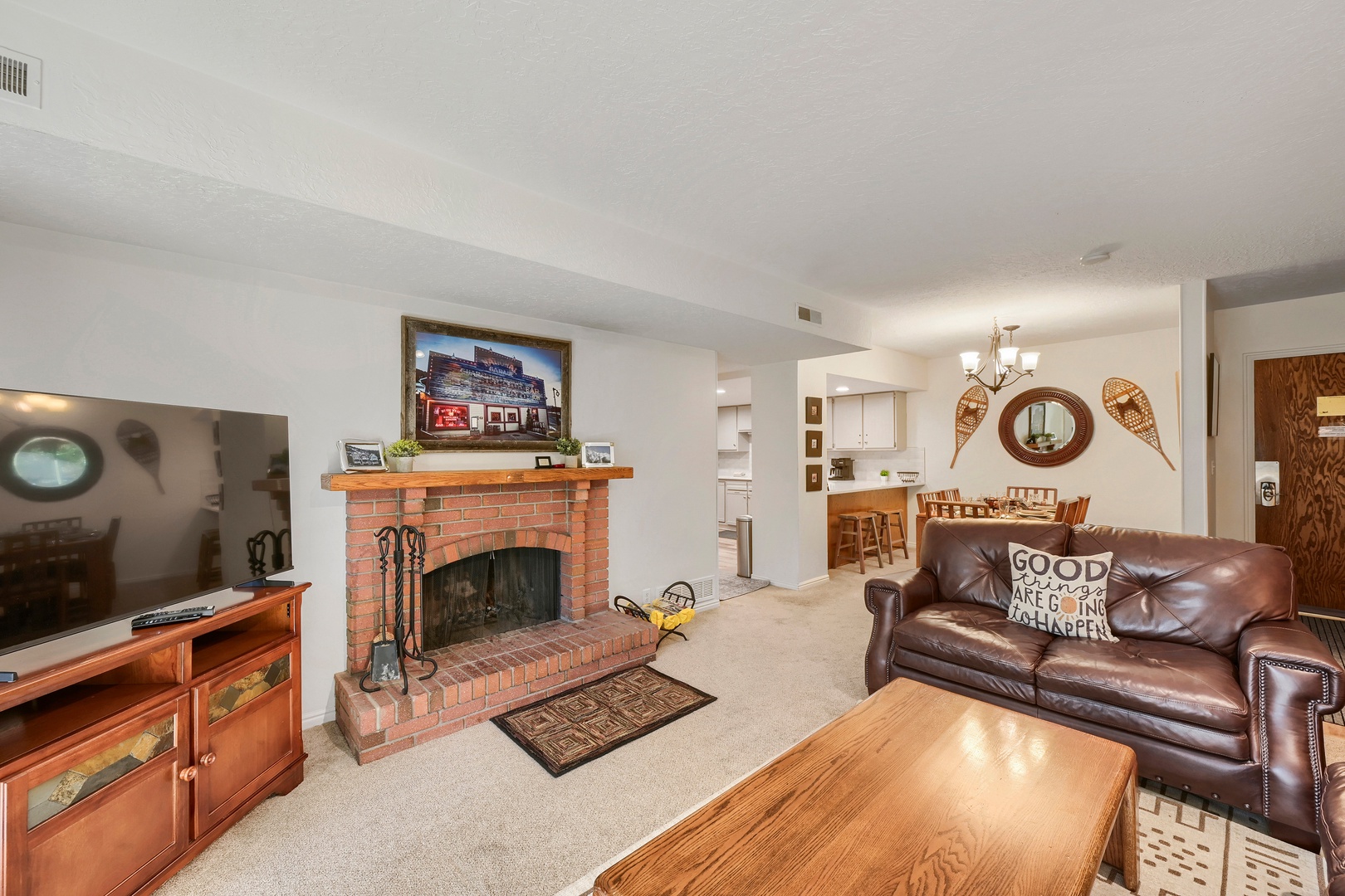 Settle into the inviting living room with a classic brick fireplace and comfortable leather seating—your cozy retreat after a day of adventure.