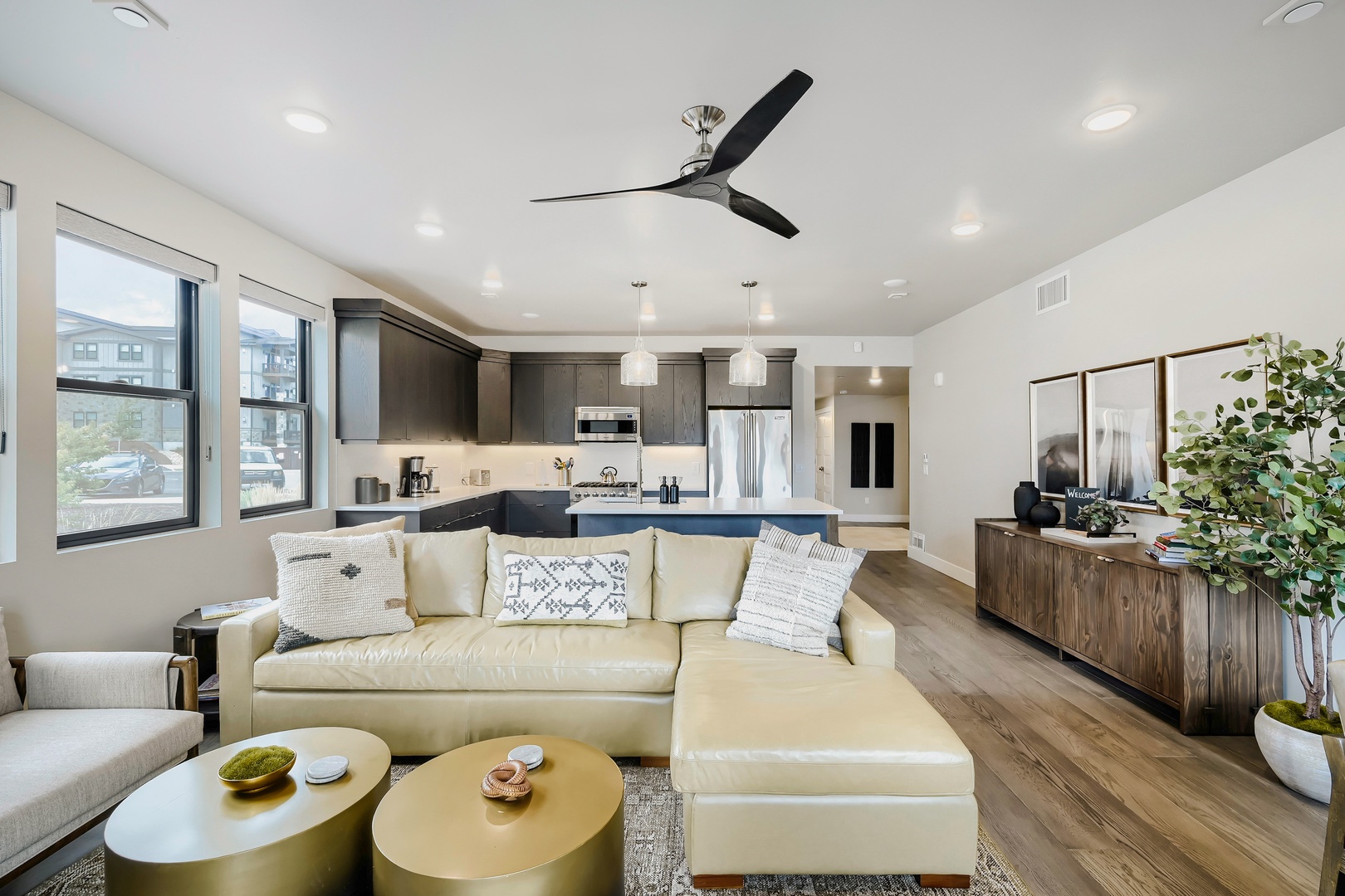 Step into your bright open-plan retreat where the living room flows seamlessly into a modern kitchen. Relax on the plush sectional under the gentle breeze of the ceiling fan, or whip up a meal surrounded by sleek appliances and stylish finishes.