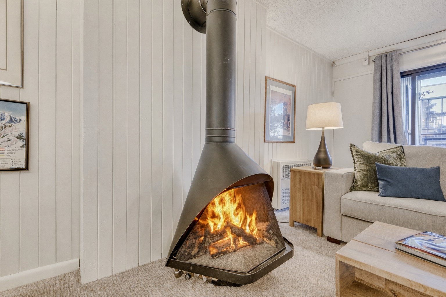 Curl up by the crackling fire in your cozy living room, where warmth radiates from the stylish modern fireplace.