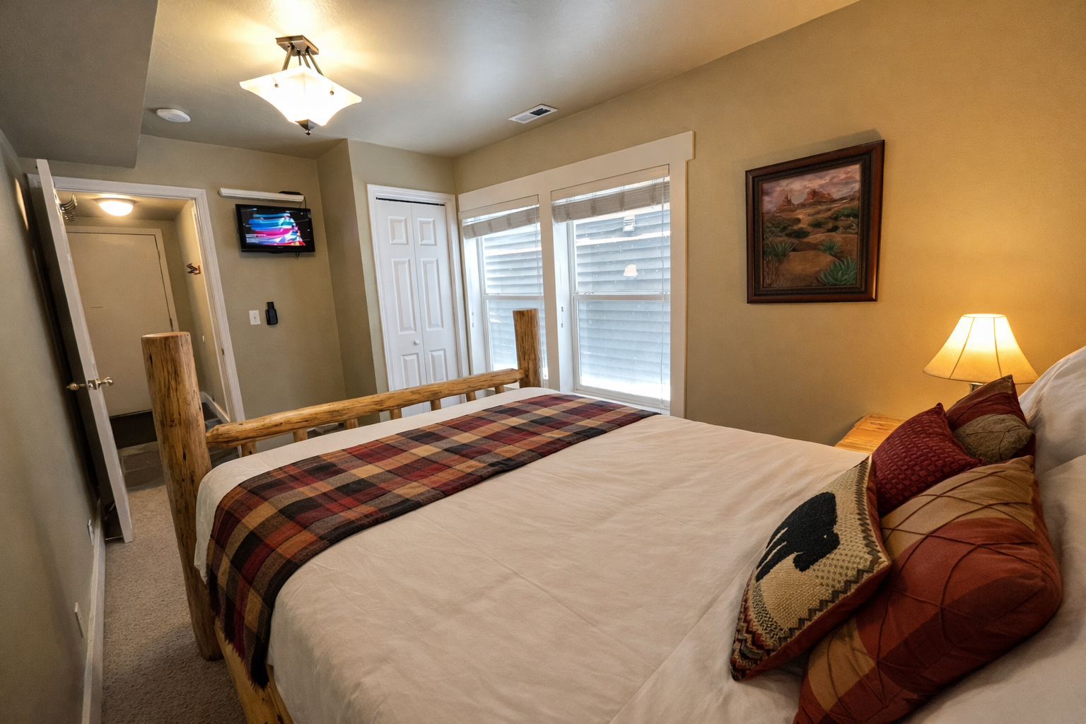 Unwind in your cozy rustic bedroom with log accents and warm colors that create the perfect mountain retreat atmosphere.