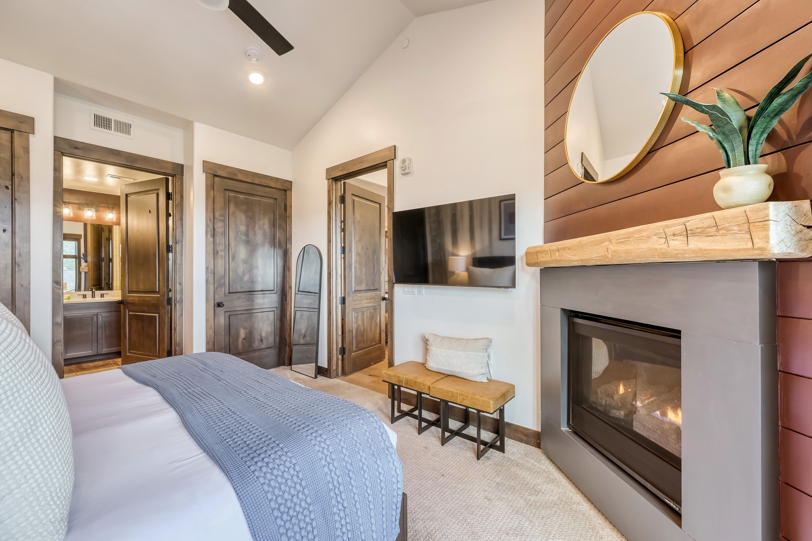 Unwind in your serene bedroom retreat, complete with vaulted ceilings, a cozy fireplace crackling softly, and rustic wood accents that bring warmth and elegance to your mountain getaway.