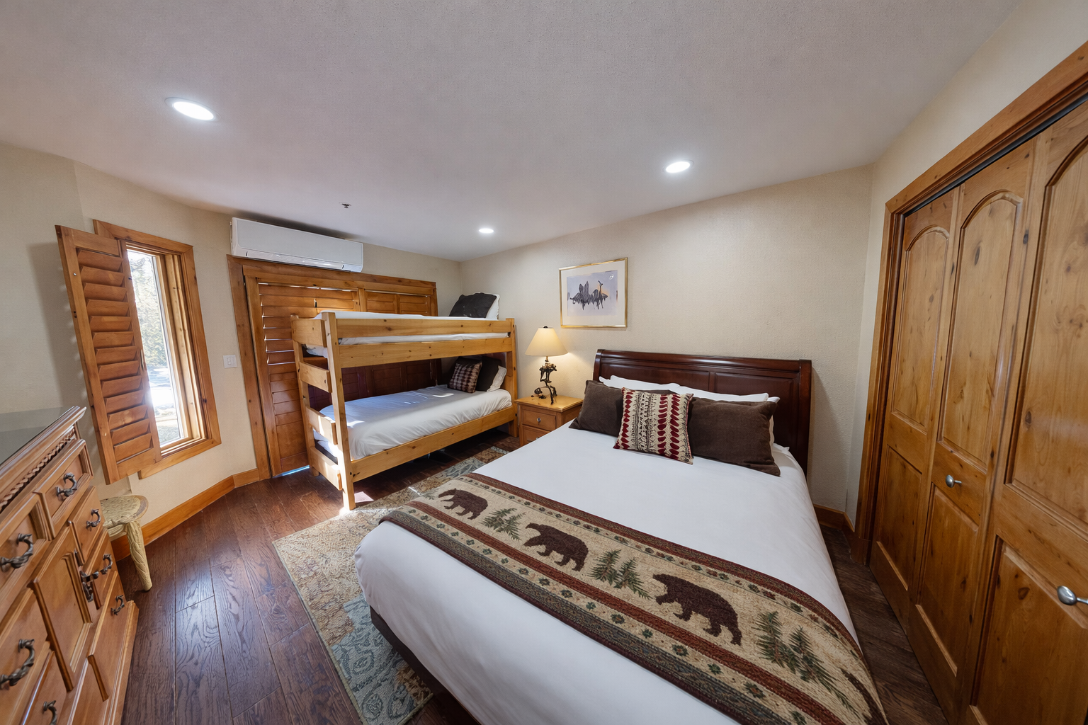 Rest comfortably in your cozy bedroom featuring a queen bed and bunk beds, perfect for families or groups seeking mountain lodge charm.