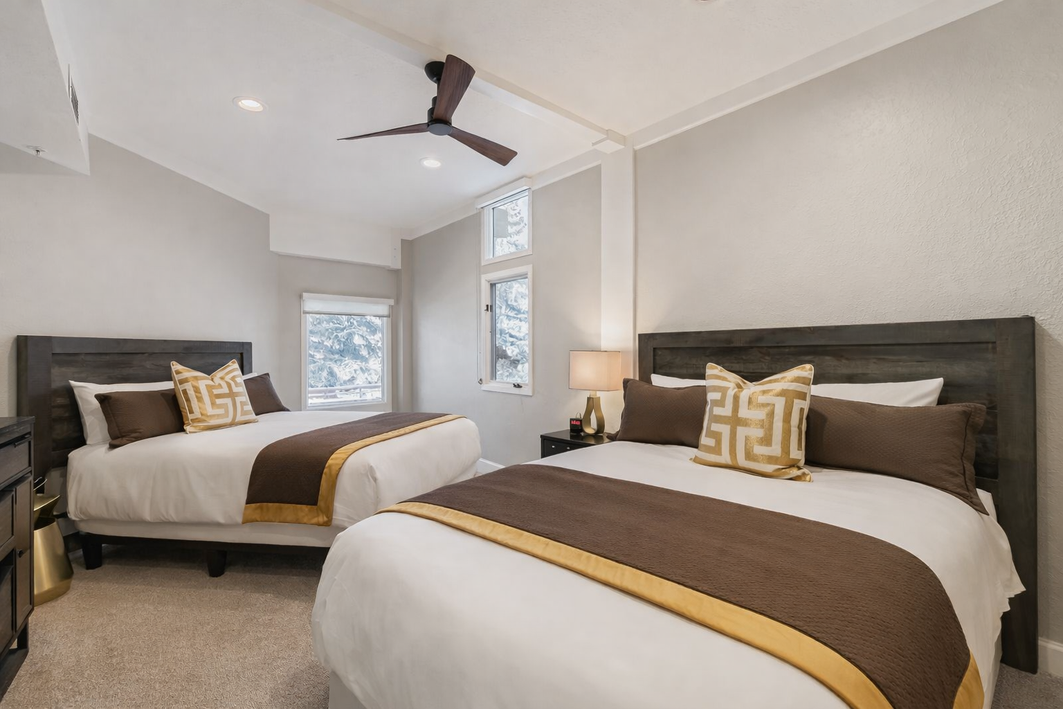 Drift off in your choice of two comfortable beds with crisp linens and golden accents in this serene room.