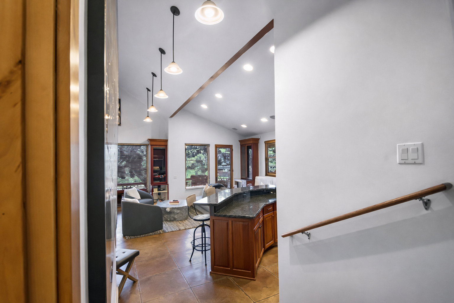 Your open kitchen flows seamlessly into the bright living space, with sleek pendant lights and natural wood touches creating a warm, modern atmosphere.