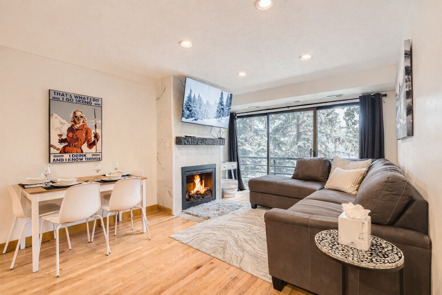 Cozy living room with a modern stone fireplace, comfy sectional sofa, and snowy window views.