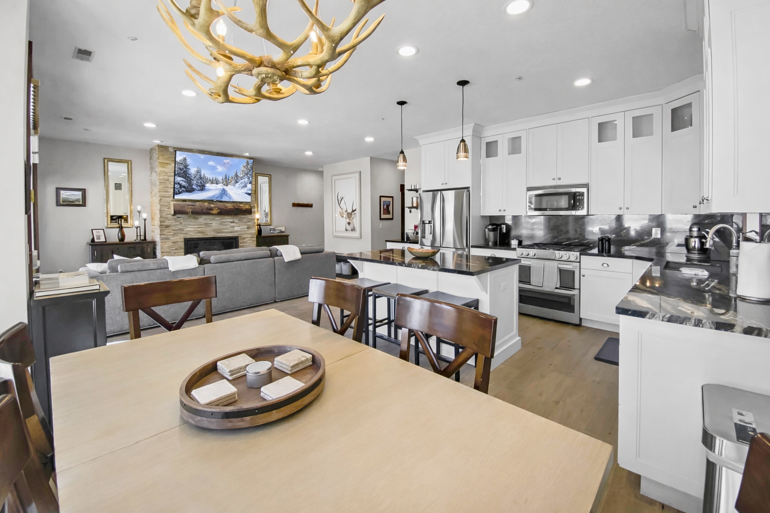 Gather around a spacious dining table that flows seamlessly into a chef-inspired kitchen and cozy living area, perfect for creating memories with loved ones in your mountain retreat.