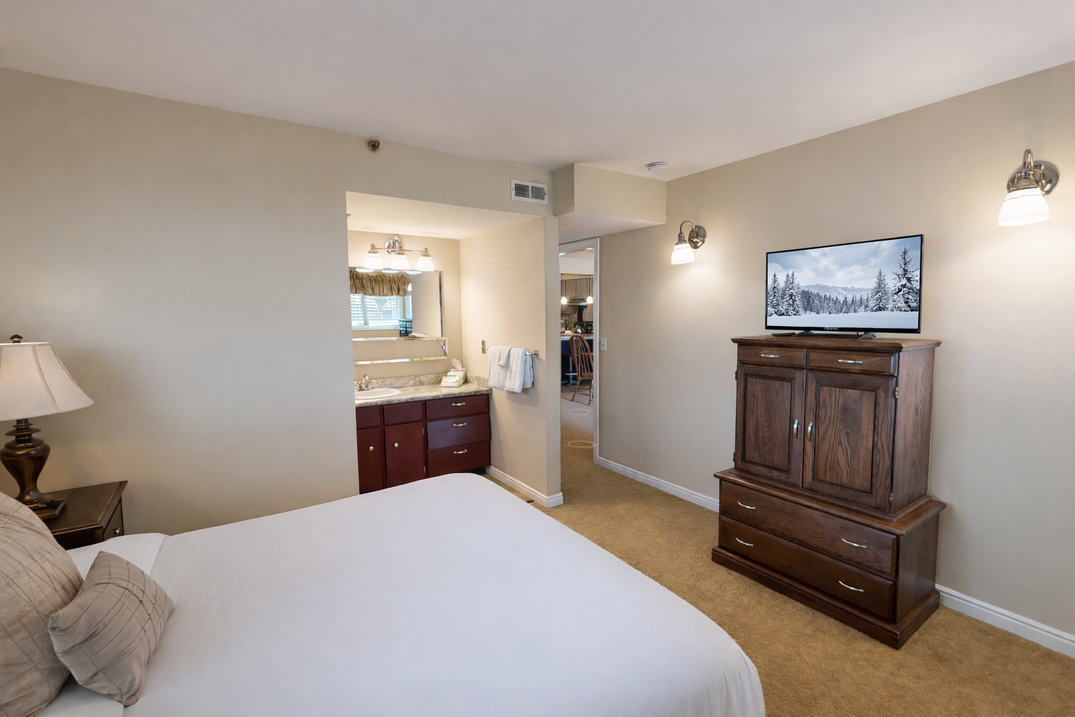 Cozy mountain retreat! Relax in this inviting king room with warm lighting, wood furniture, and an ensuite bath.
