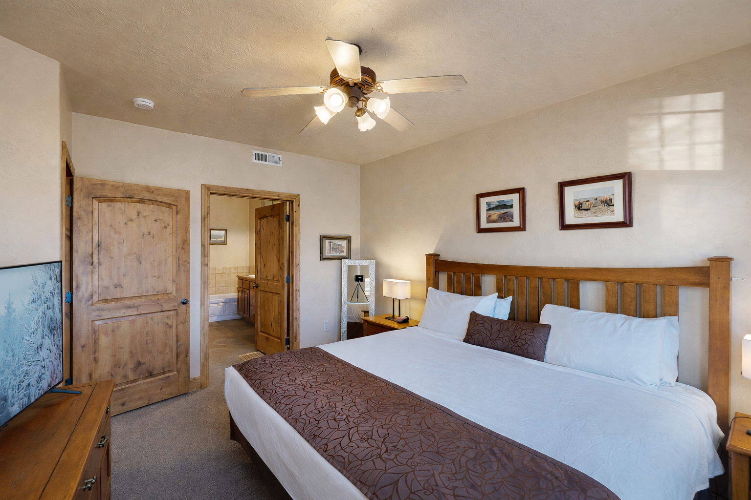 Sink into crisp white linens and rustic wood charm. Your spacious retreat features modern comfort with warm touches.