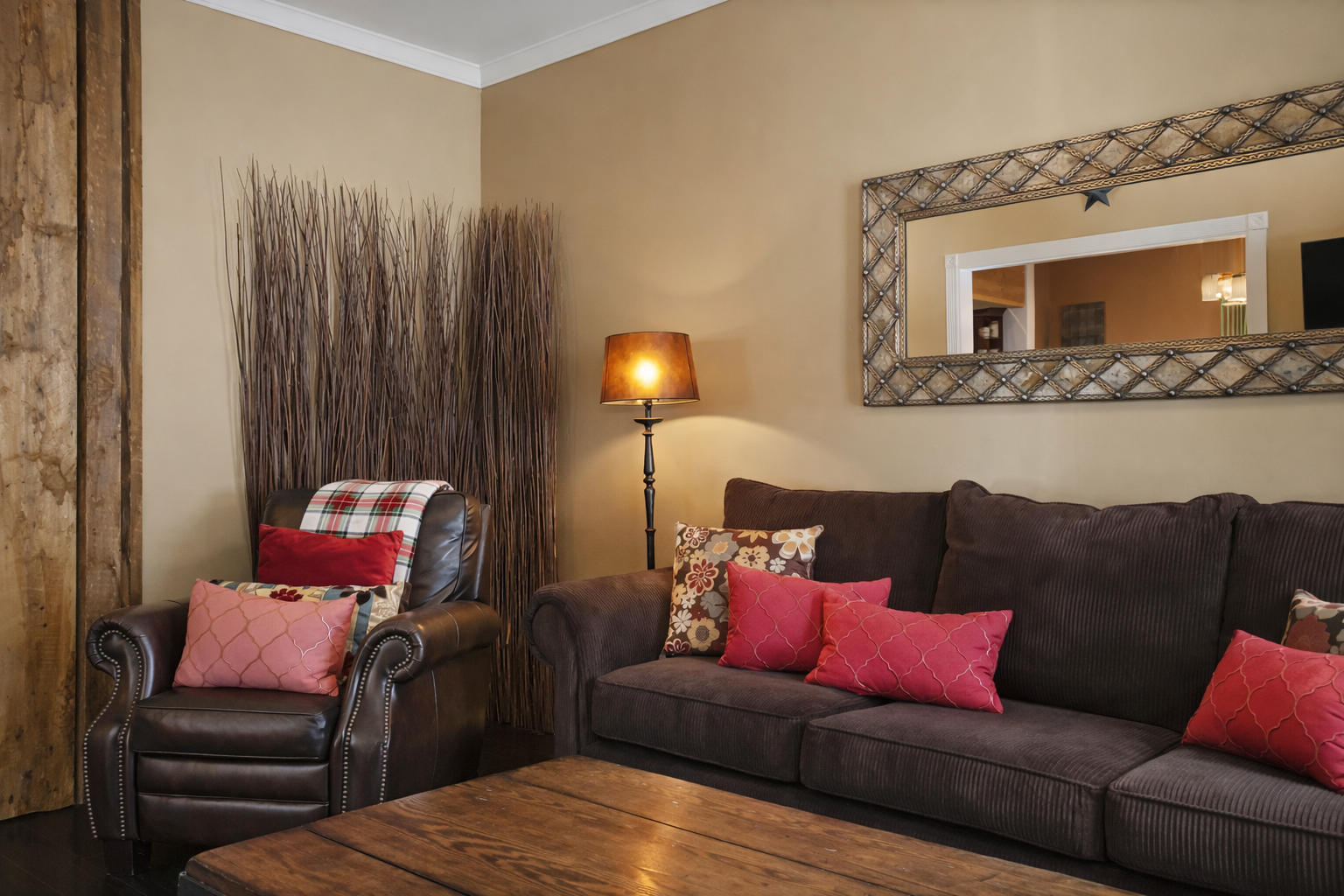 Unwind in your cozy living room with plush seating, entertainment center, and warm burgundy accents for relaxing evenings.
