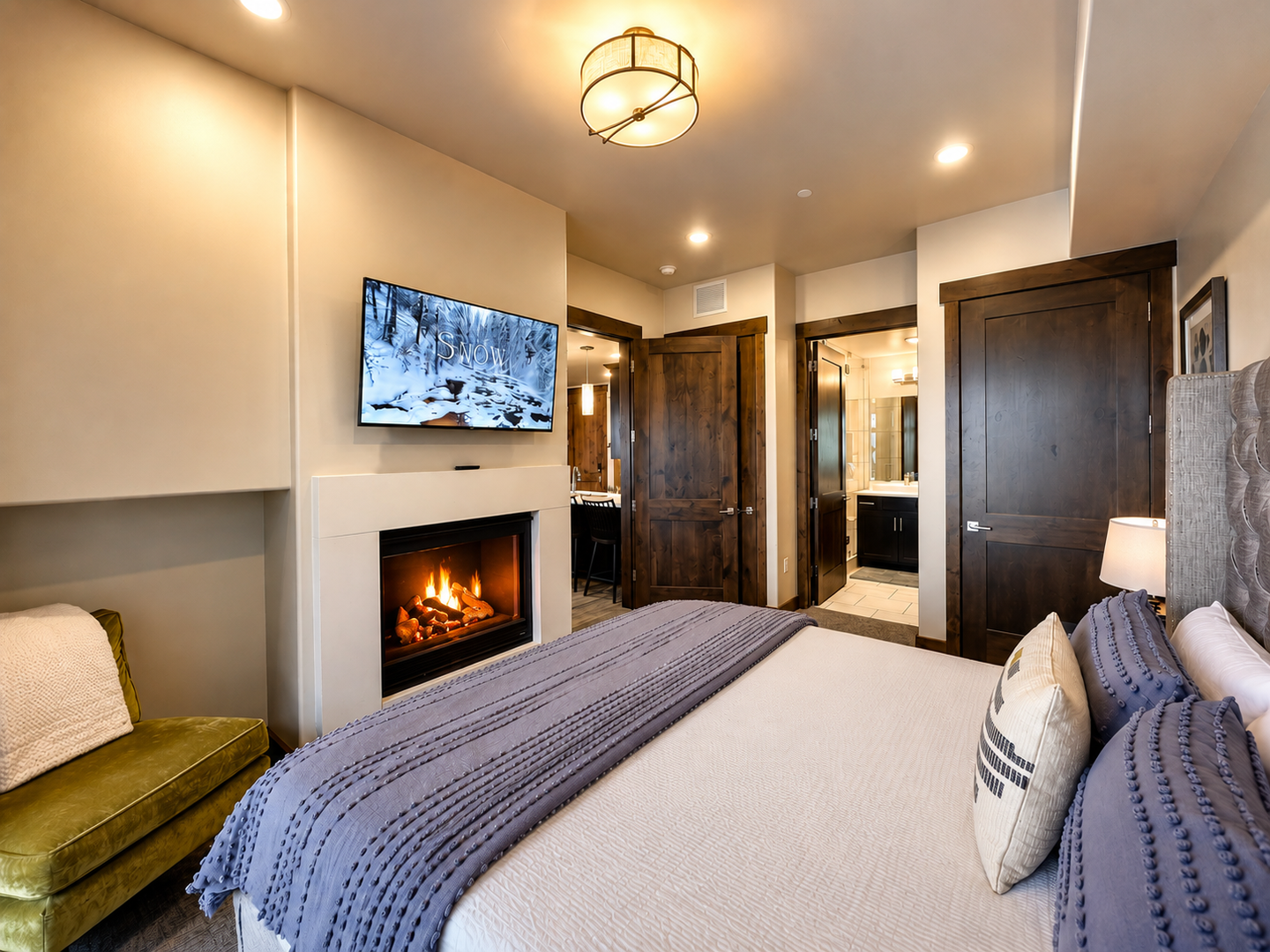 Unwind in your cozy bedroom with a crackling fireplace, plush bed, and modern entertainment. Your peaceful mountain retreat awaits, complete with elegant touches and an ensuite bathroom just steps away.