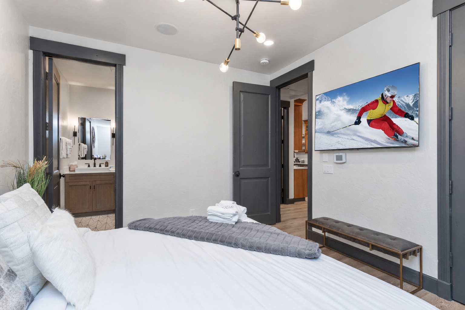 Relax in this stylish, modern bedroom featuring a large king-size bed, natural light, and chic decor. The perfect retreat after a day of Park City adventures.