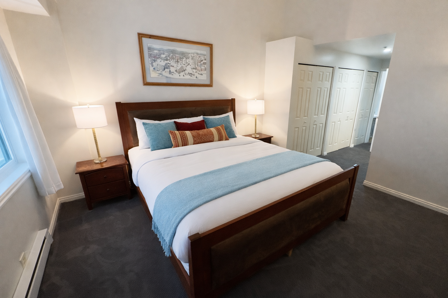 Peaceful guest bedroom featuring a comfortable bed, ceiling fan, and lovely artwork. A tranquil retreat for a restful stay in the mountains.