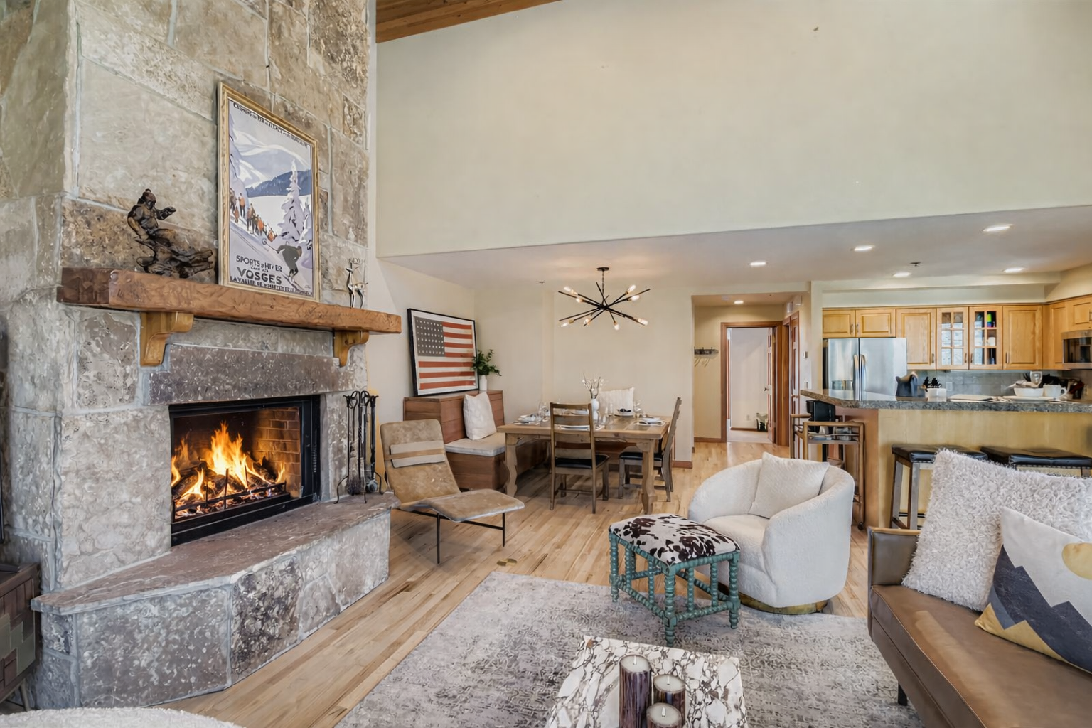 Escape to a cozy, rustic retreat! Enjoy this charming mountain living room featuring a stone fireplace, natural wood beams, and comfortable seating.