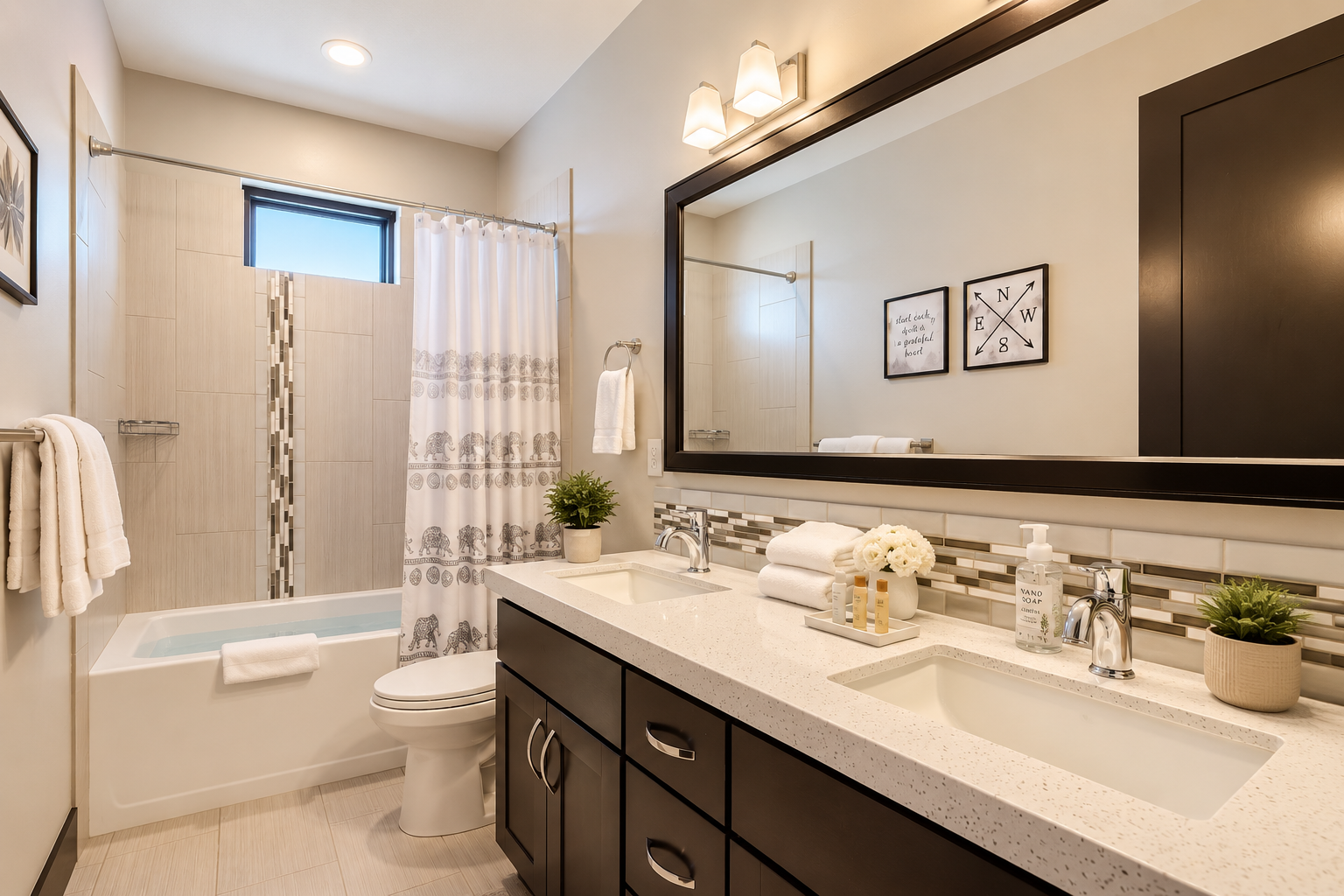 Refresh in this modern double vanity bath featuring a spacious mirror, elegant tile accents, and a clean tub/shower combo—a bright and airy sanctuary for your group.