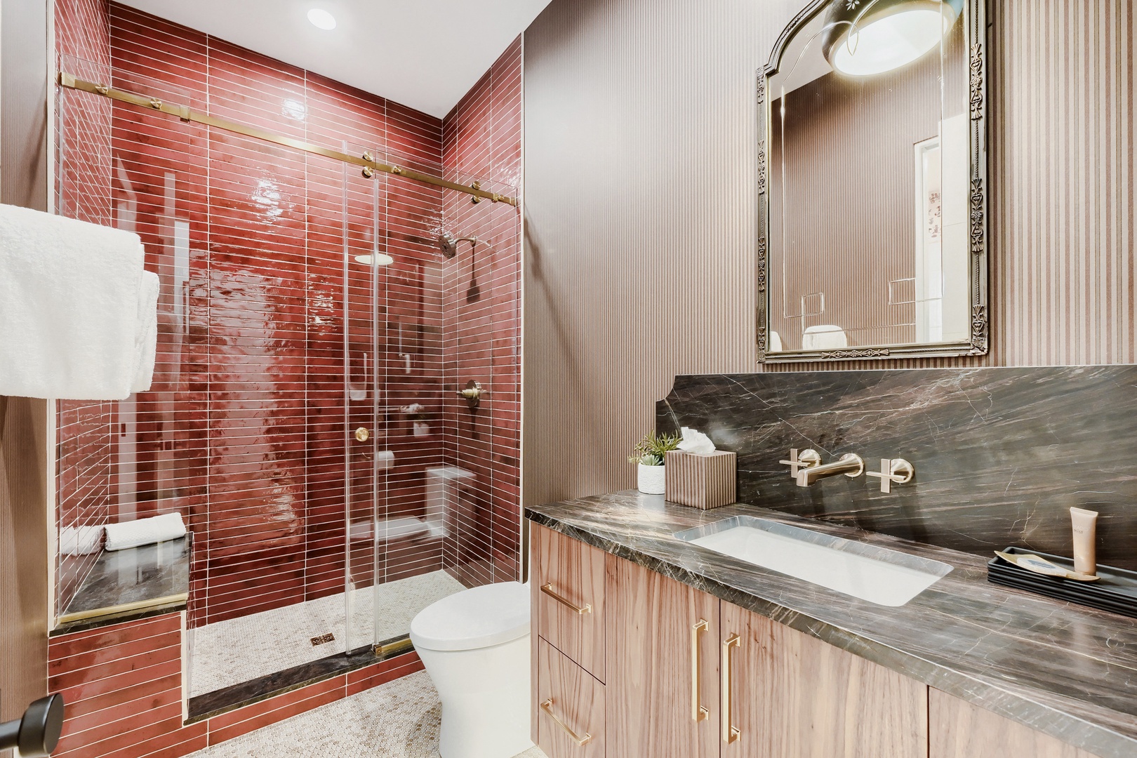 Freshen up in your elegant bathroom featuring a spacious walk-in shower with stunning red tile, elegant fixtures, and refined finishes throughout.