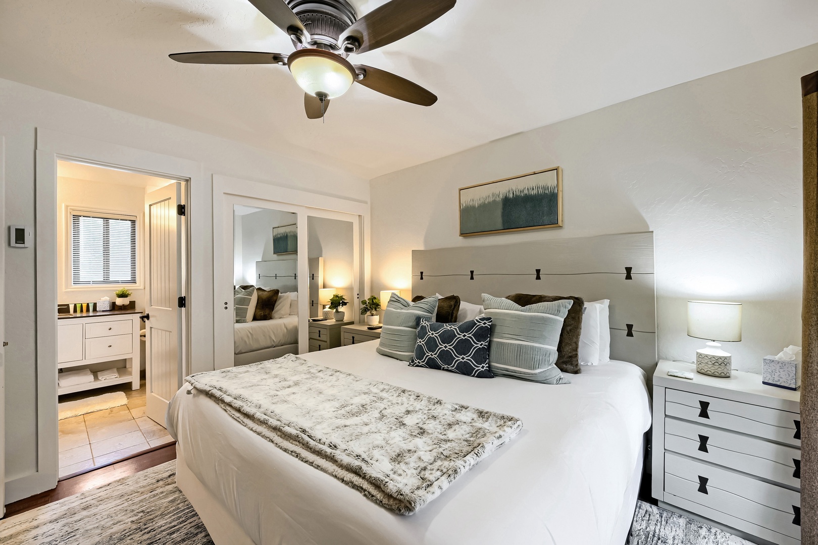 Unwind in your private retreat with crisp linens, coastal textures, and a ceiling fan to keep you cool. The en-suite bathroom and thoughtful décor create a restful haven for your stay.