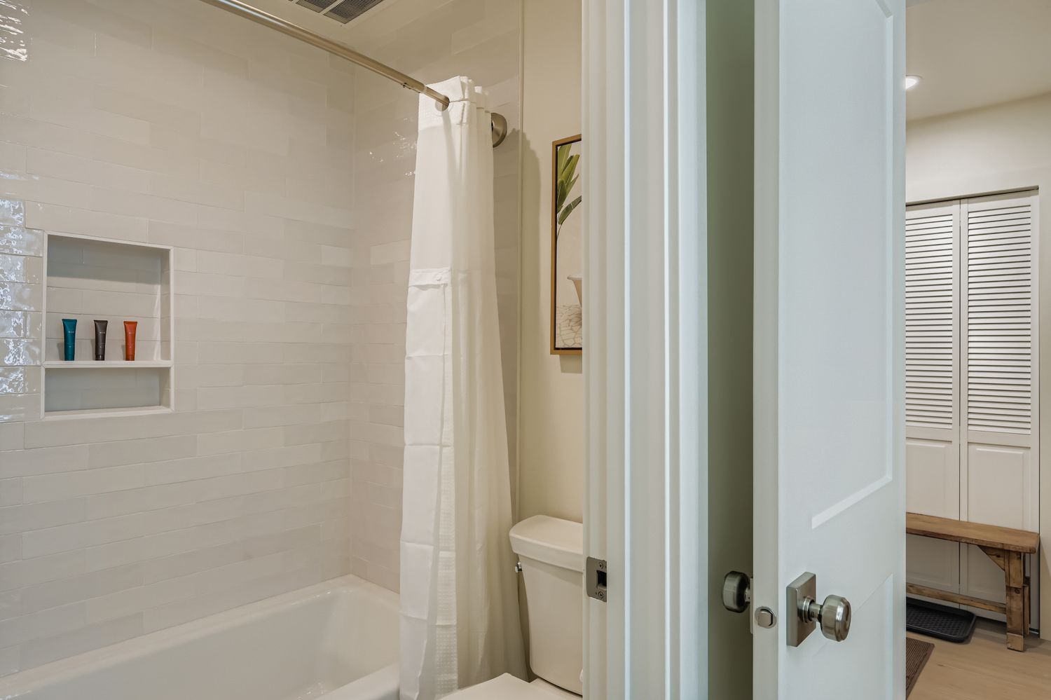 Step into your private bathroom featuring a full tub-shower combo with convenient built-in shelving to keep your essentials organized during your stay.