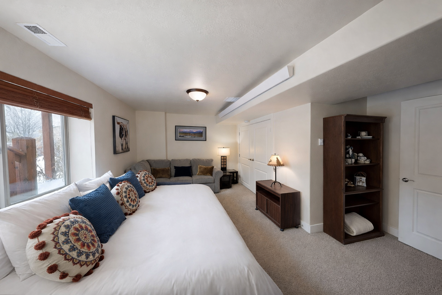 Unwind in your spacious retreat featuring a plush navy bed and cozy gray sofa, perfect for relaxing after exploring the area.