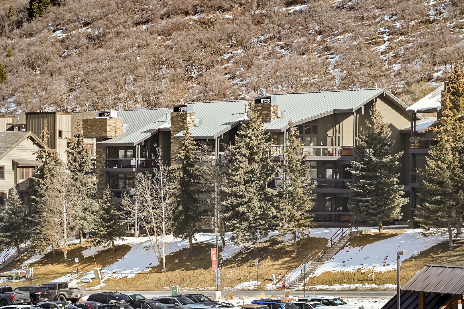 Mountain resort property featuring multi-story buildings with stone and wood facades nestled against hillside terrain.