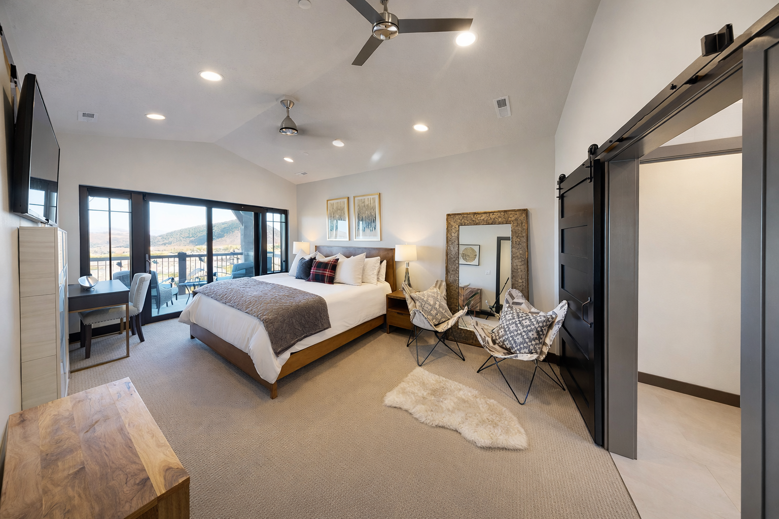 Relax in your spacious bedroom with mountain views, cozy seating area, and modern sliding barn doors leading to your private ensuite.
