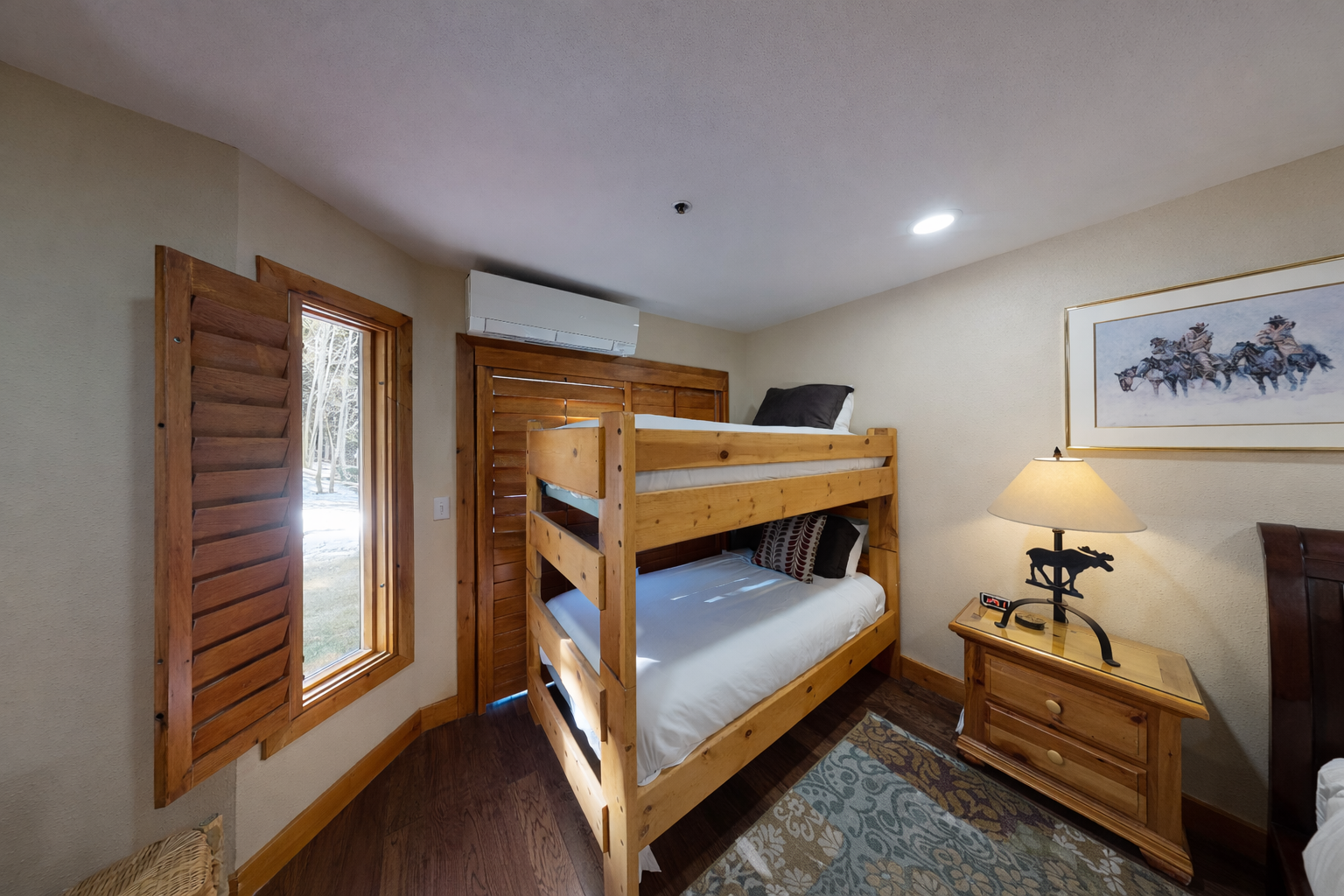 Your cozy bunk room features rustic wood furnishings and mountain-themed art, perfect for family adventures or friend getaways.
