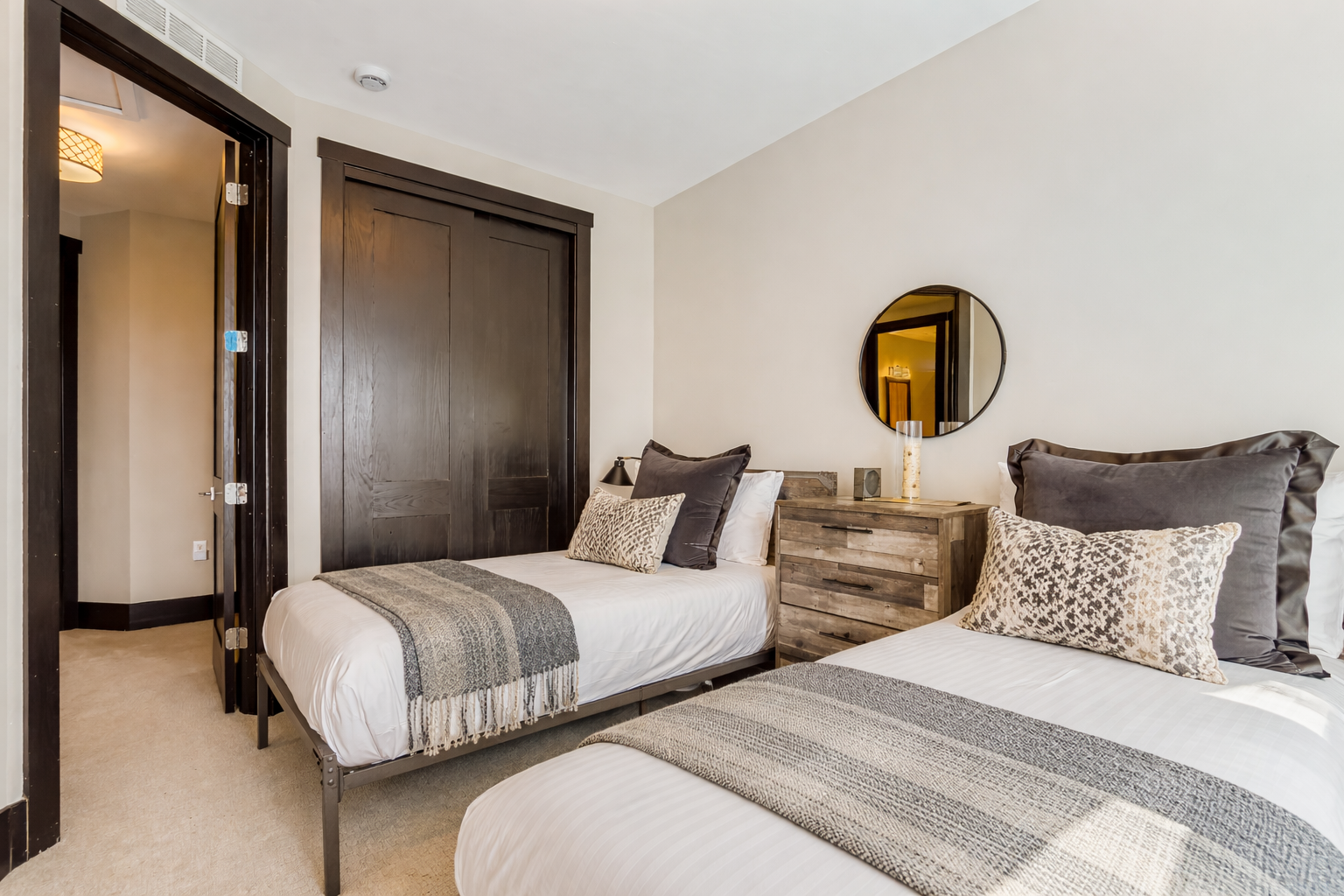 Drift off in comfort with twin beds dressed in plush linens and textured throws, creating your perfect retreat.