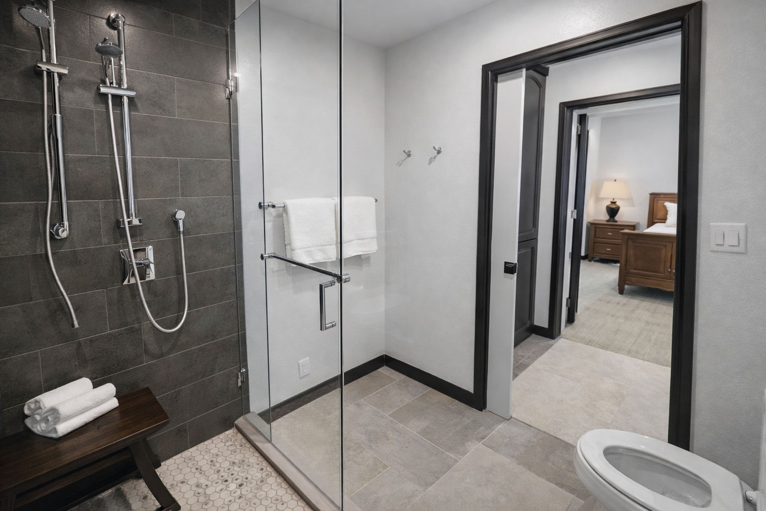 Modern & clean full bathroom featuring a spacious walk-in shower with sleek glass enclosure, a large mirror, and high-quality fixtures.