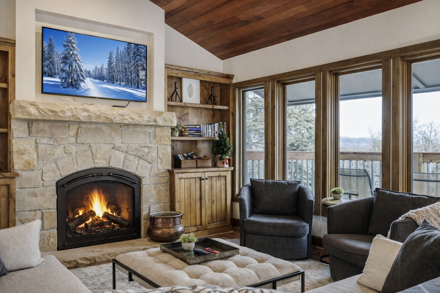 Cozy up by the crackling fireplace in this elegant living space where warmth meets mountain views through expansive windows.