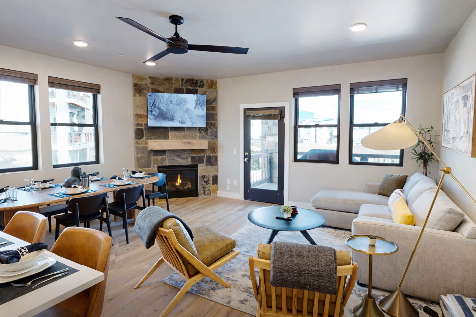 Unwind in this modern Park City living space featuring a sleek stone fireplace, mid-century furnishings, and an open dining area.