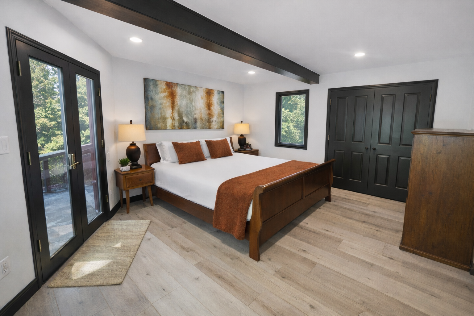 Your spacious master bedroom features warm wood tones, exposed beams, and French doors opening to your private outdoor space.