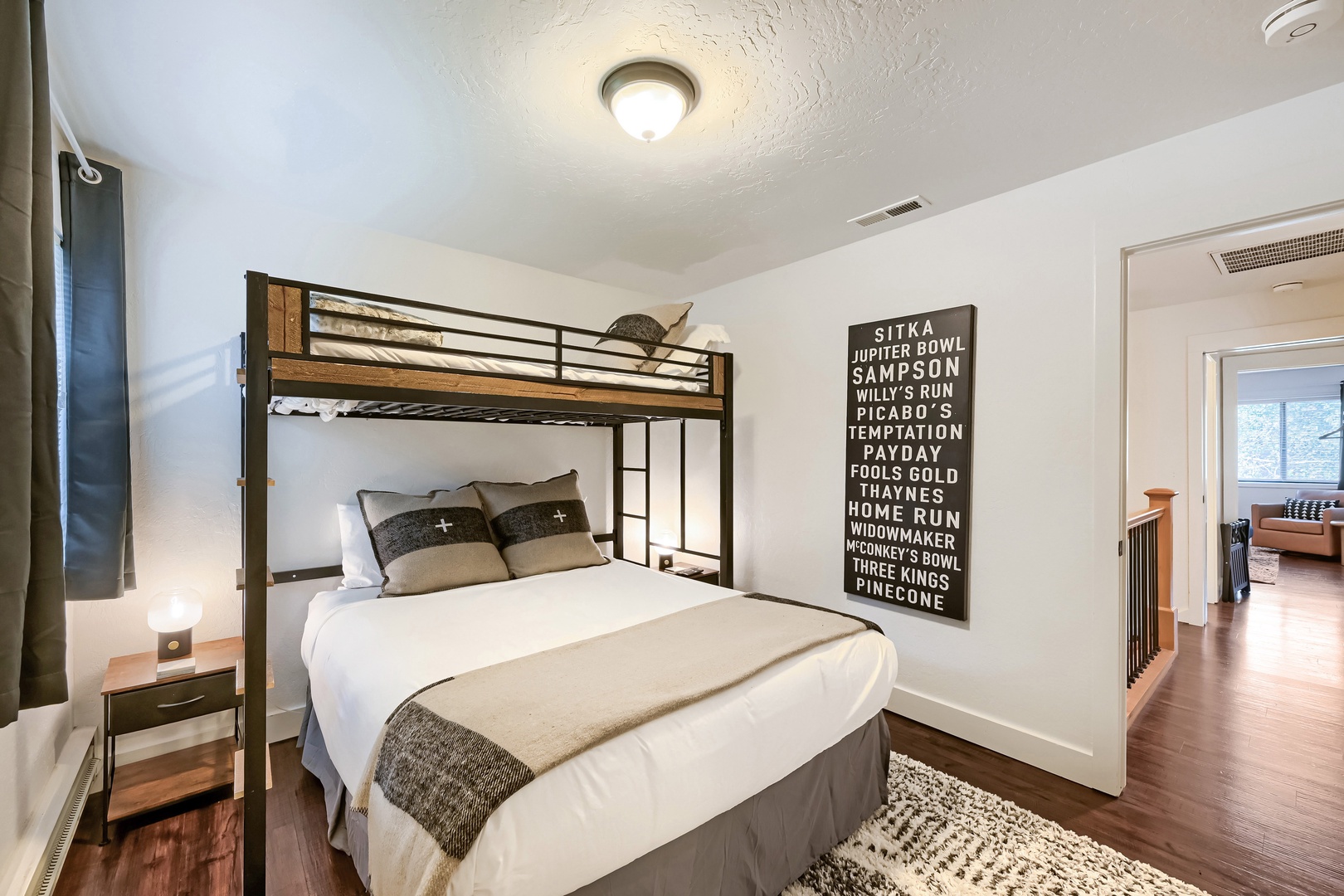 Rest easy in this cozy bedroom where modern comfort meets smart space. Your bunk bed and plush queen-size bed offer flexible sleeping options for your group, while warm wood tones and natural textures create a welcoming retreat.