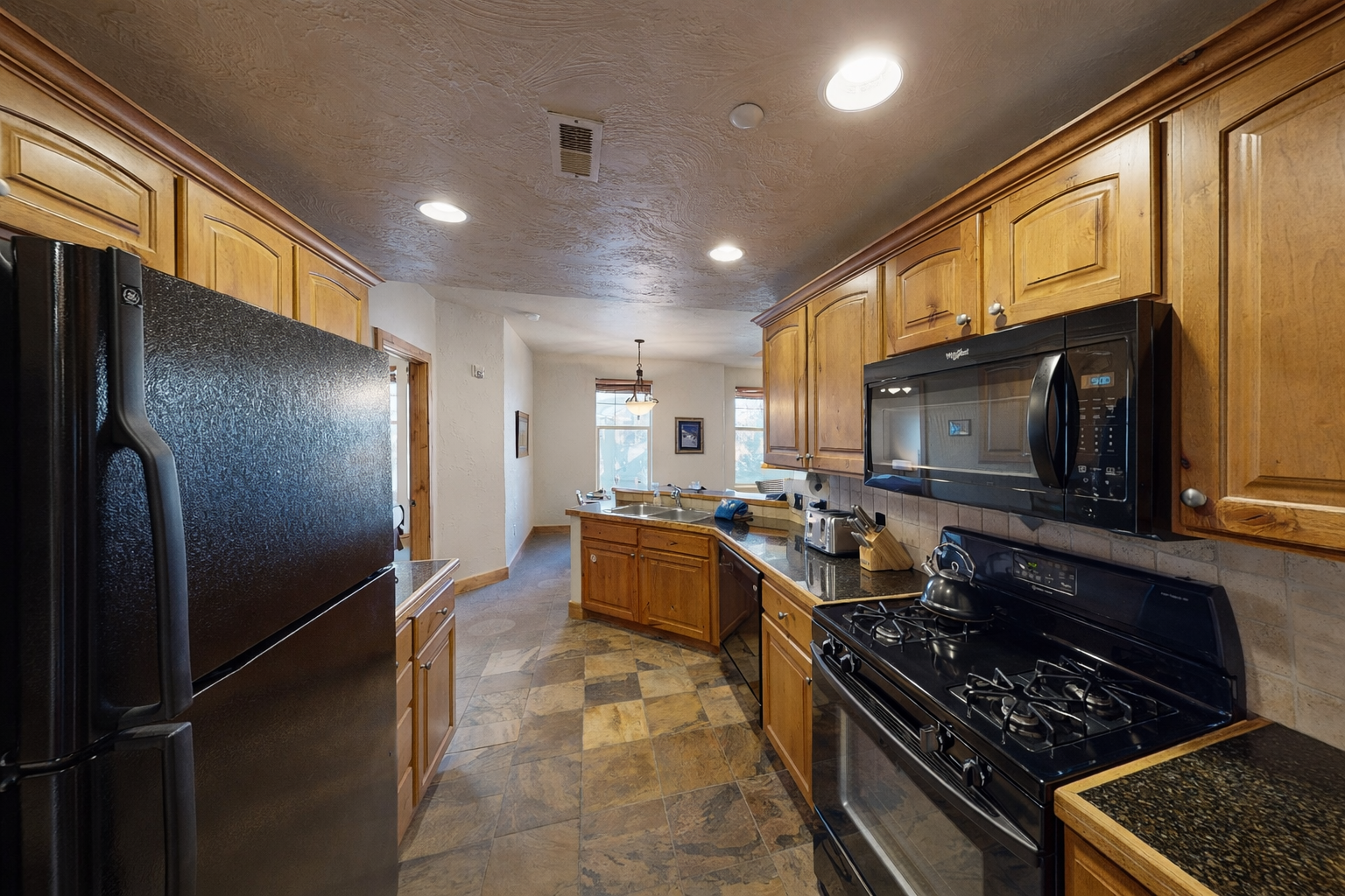 Your fully equipped kitchen features granite counters, stainless appliances, and warm wood cabinets for memorable meal preparation.