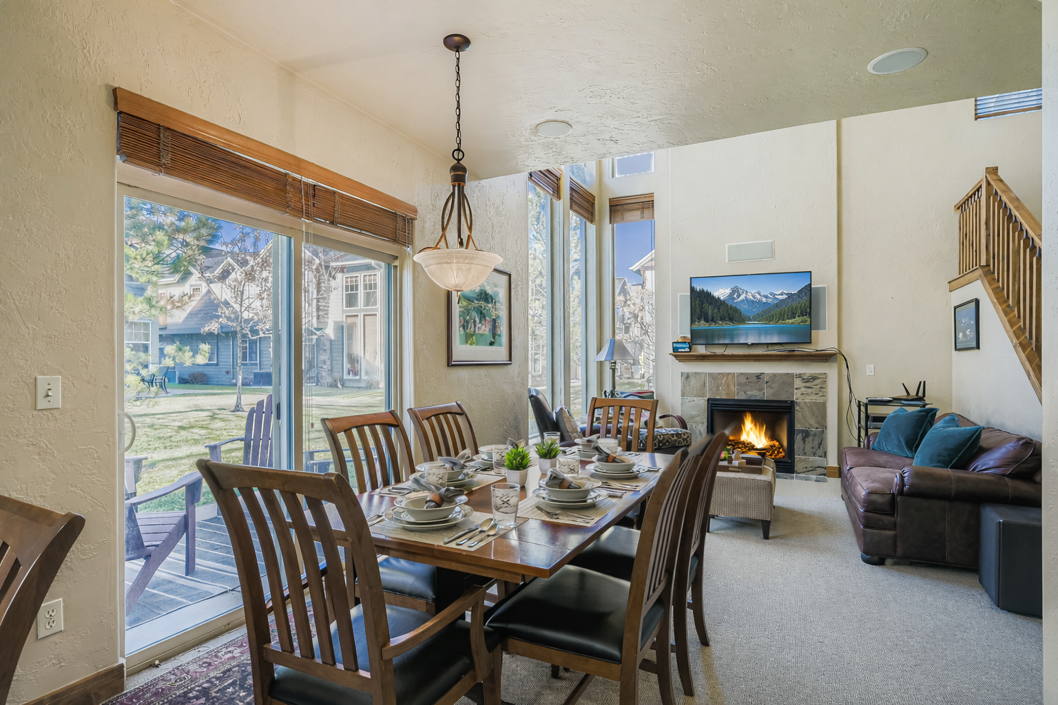 Your open-concept dining and living area features elegant furnishings, a cozy fireplace, and large windows that flood the space with natural light for memorable meals and relaxation.