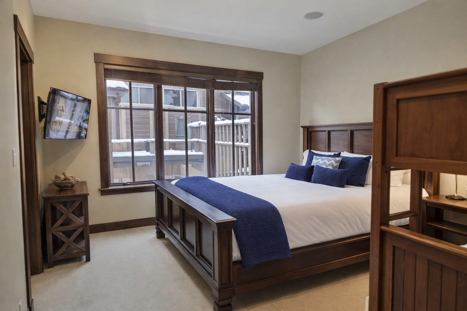 Sink into your cozy bedroom retreat with rich wood furnishings and crisp linens, where peaceful mountain views await outside your window.