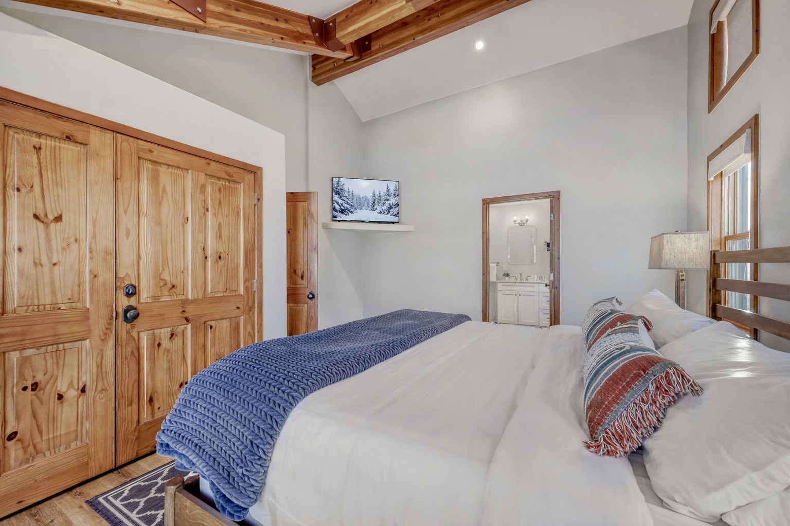 Drift off under rustic exposed beams in this cozy bedroom, where warm wood details and crisp linens create your perfect mountain retreat.