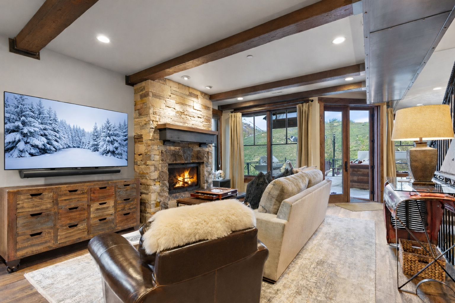 Curl up by your crackling stone fireplace with exposed beams overhead and mountain views beyond sliding doors.