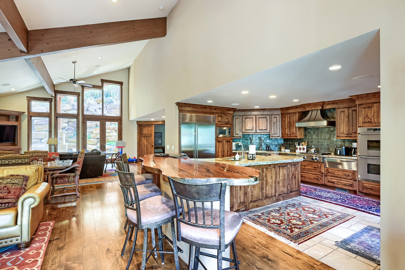 Gather around the handcrafted wood island in your gourmet kitchen, where rustic warmth meets modern appliances. Vaulted ceilings and natural light create an open, airy space perfect for cooking and conversation.