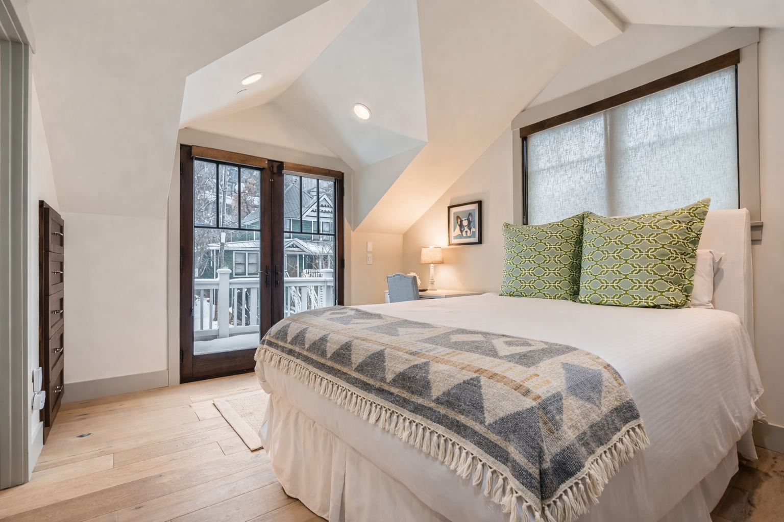 Retreat to the stylish master suite featuring a large king-size bed, natural light, modern decor, and a cozy rug. The perfect sanctuary after exploring Park City.