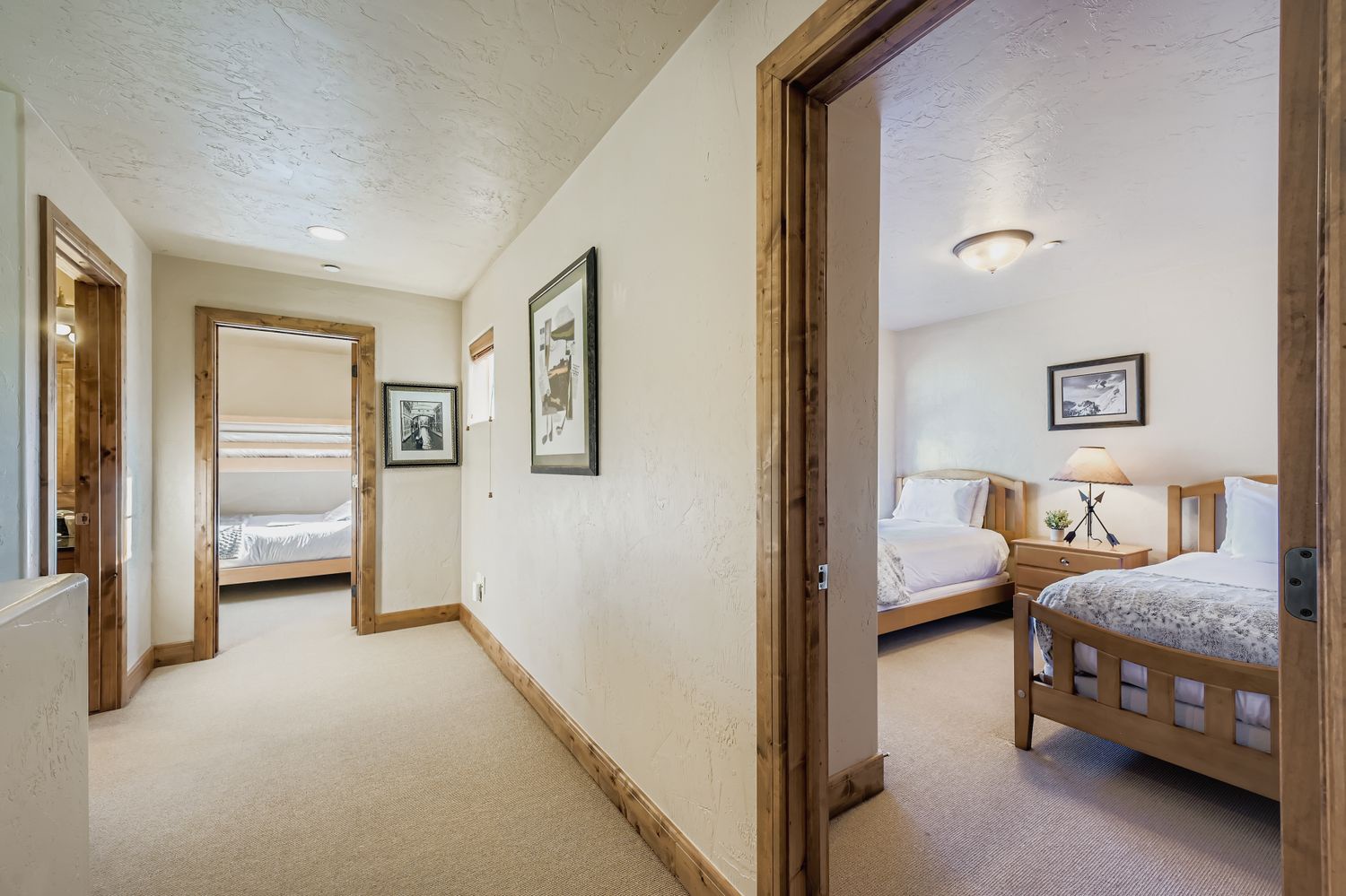 Your cozy hallway connects multiple comfortable bedrooms, each thoughtfully designed with warm wood accents and quality furnishings for a restful stay.
