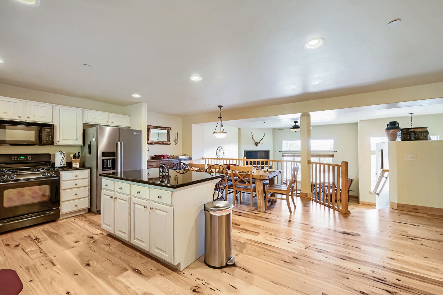 Your open-concept kitchen and dining area invites easy gathering, with warm hardwood floors and natural light flowing through expansive windows. Cook, dine, and relax in this bright, spacious home away from home.