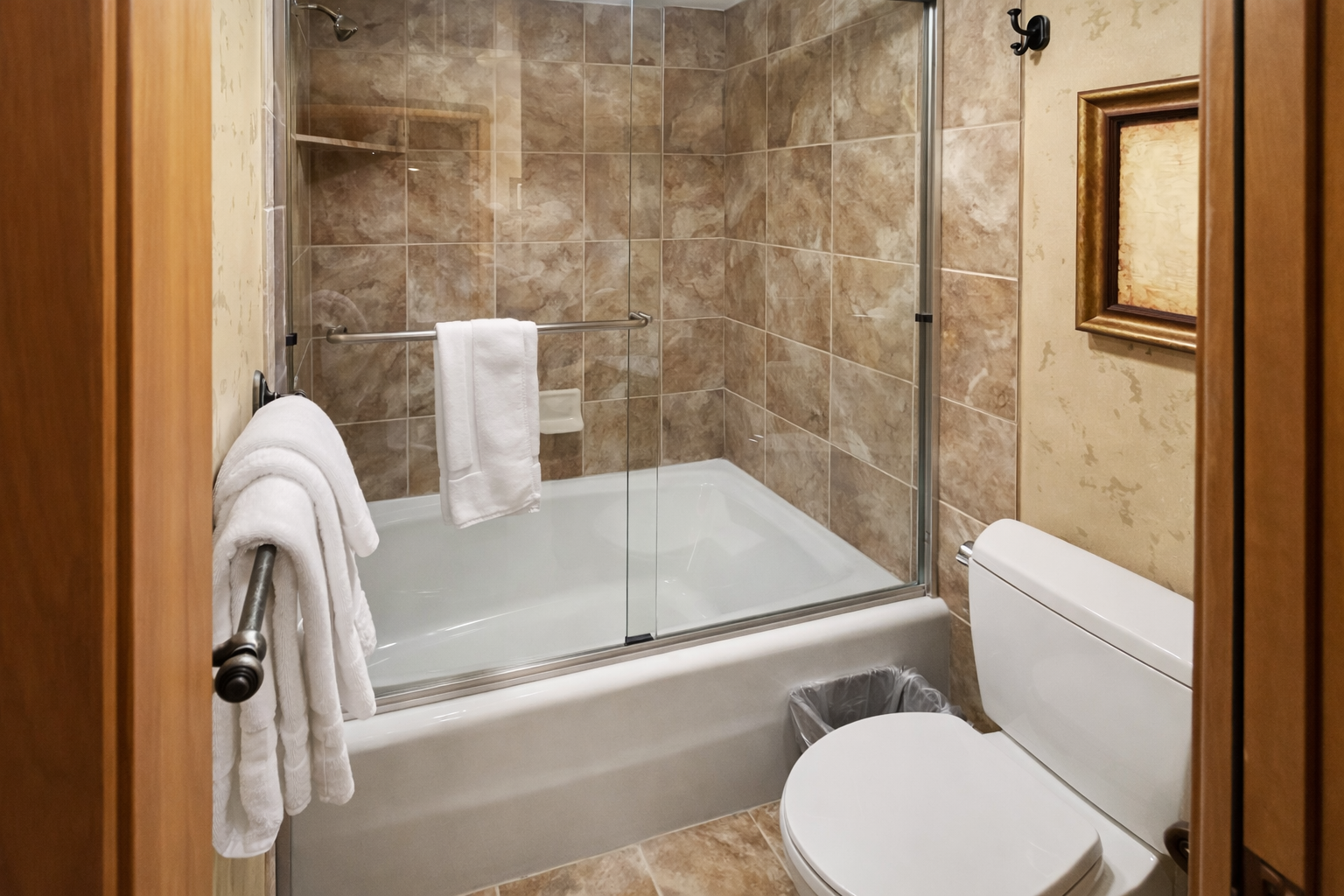 Unwind in your elegant bathroom featuring granite counters, rich wood cabinetry, and a soothing tub-shower combo for relaxing after your adventures.